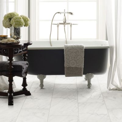 marble look tile floors in a bright white bathroom with a tub